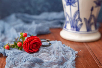 Coral Roses arranged in a Blue Vase with Blue Background on Wood Table