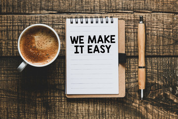 We make it easy text in the notebook on a wooden table. Top view - business concept.