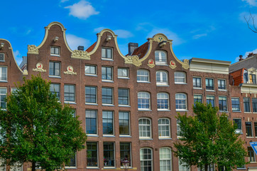 Amsterdam, Holland, August 2019. The typical and charming houses: they are a symbol of the city represented on a postcard. With brightly colored brick facades and distinctive roofs.