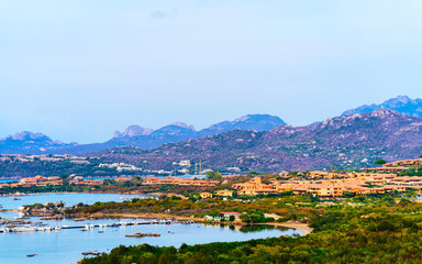 Obraz premium Landscape and scenery of Golfo Aranci atSardegna island in Italy in summer. Sassari province near Olbia and Cagliari. In Mediteranean sea. Yachts, boats and ships. Mixed media.