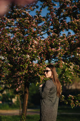 Attractive girl stand in front of beautiful blooming tree