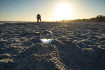 Glaskugel Fotografie am Strand bei Sonnenuntergang mit Mann im Hintergrund
