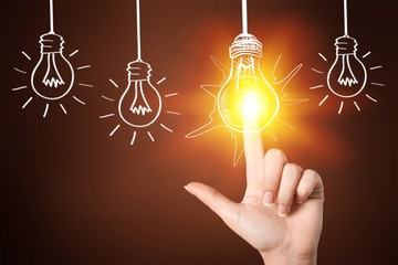 Hand turning off the bulb lamp, on  background