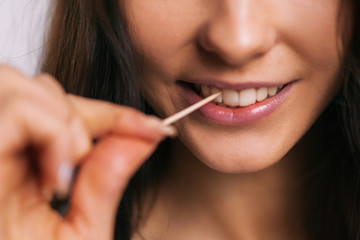 girl brushing her teeth with a toothpick