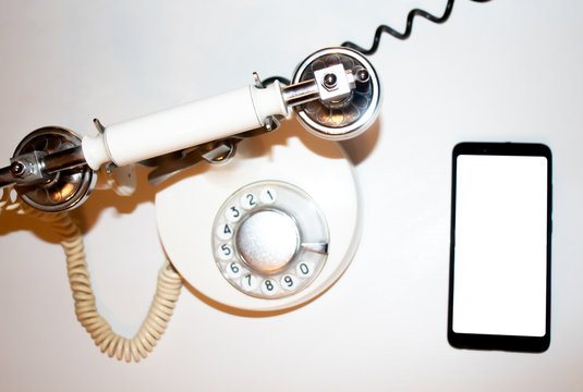 old telephone and smart phone on white background