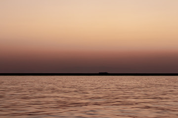 a wide seascape shoot with very well composed colors and black horizon from izmir bay - orange color dominated