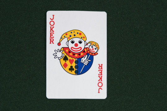 The Playing Card Joker on green card table top