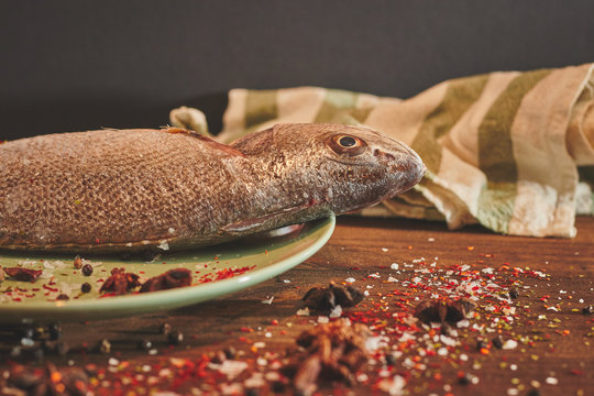 Fresh sea fish over green plate