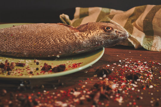 Fresh sea fish over green plate