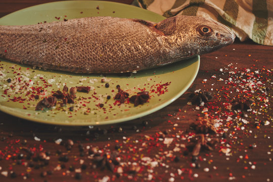 Fresh sea fish over green plate