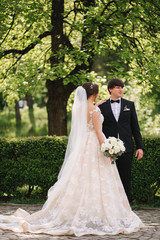 Happy groom and bride walking in the park. Charming woman with handsome man spend time together