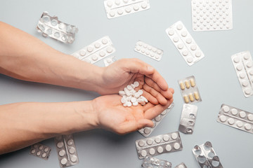 Medication and white pills in the hand. View from above