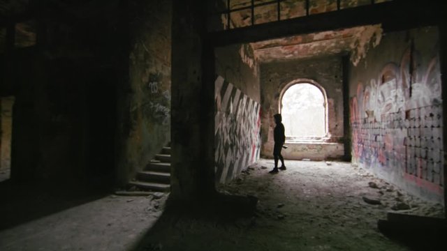Young Urbex Explorer with camera checking out old brick walls in a old Abandoned Hospital, Slow motion