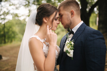 Portrait of gorgeous bride and handsome groom in forest
