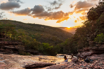 Obraz premium Tourists admiring sunset from rocky river in the middle of tropical jungle in Brazil
