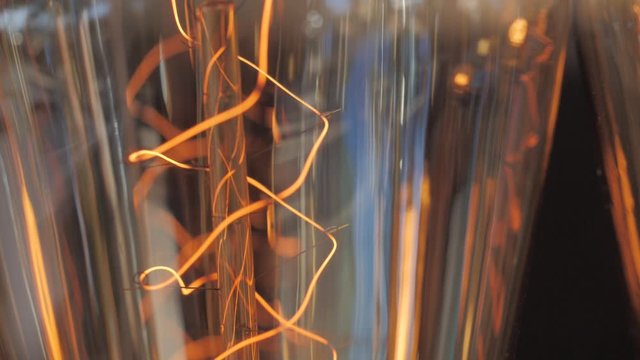 Close up of dusty vintage edison lamp, retro bulb on black background