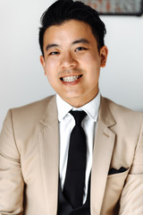 Portrait of handsome asian groom in stylish suit with necktie