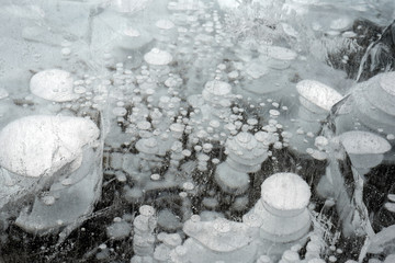 Trapped methane bubbles frozen into the water under the thick cracked and folded ice on Abraham...