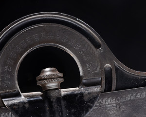 Gray and black old carpenter protractor close-up studio shot