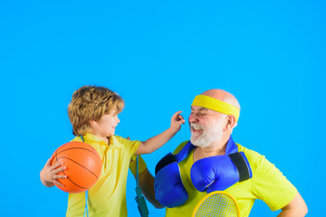 Family time. Grandfather and kid playing. Family sport. Old man with dumbbells. Portrait of healthy...