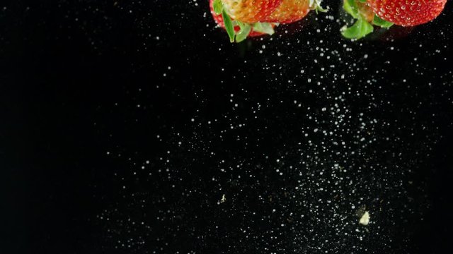 5 strawberries splash into water against black background red helium 8k 60p