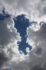 white Cumulus clouds for a dark thunderstorm in a blue sky with a clear view of a picturesque natural phenomenon