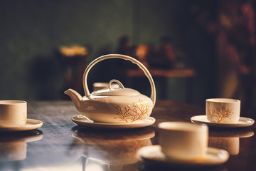 Teapot on the table near cup of tea.