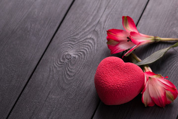 Valentines day concept. Red heart velvet cake on a wooden black background with a delicate Alstroemeria flowers