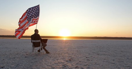 American business - an adult guy in a jacket works with a laptop on a beautiful yellow sunny dawn background - Powered by Adobe