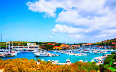 Scenery with Marina and luxury yachts at Mediterranean Sea of Porto Cervo in Sardinia Island of Italy in summer. Landscape View on Sardinian town port with ships and boats in Sardegna. Mixed media.