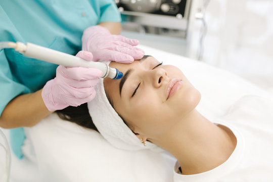 Close-up of woman getting facial hydro microdermabrasion peeling treatment. Female at cosmetic beauty spa slinic. Hydra vacuum cleaner. Cosmetology
