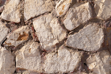 Background of limestone masonry. The surface is decorated with natural material. The wall is made of wild stone.