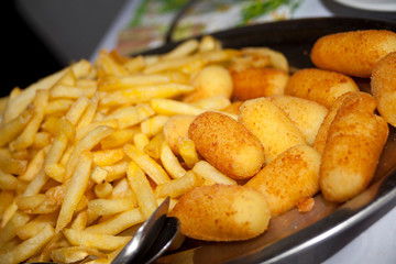 Pommes und Kroketten auf einem Tablett im Restaurant. Kartoffel Beilagen