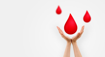 Fototapeta premium World Blood Donation Concept : Female hand holding red blood falling down with gray background.