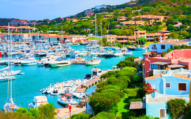 Scenery with Marina and luxury yachts at Mediterranean Sea of Porto Cervo in Sardinia Island of Italy in summer. Landscape View on Sardinian town port with ships and boats in Sardegna. Mixed media. - obrazy, fototapety, plakaty
