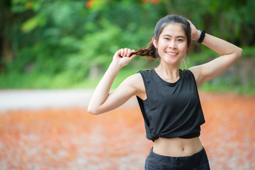 Portrait of young athlete runner woman standing in the park and looking to camera. Conceptual of healthy and sport women.