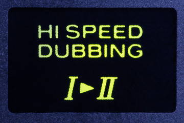 Macro close up photograph of vintage tape machine hi speed dubbing function indicator light.