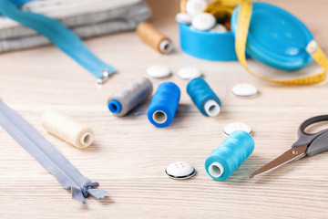 Accessories to sewing - fabric, a thread and a button. Selective focus. Copy space