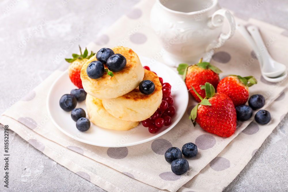 Wall mural Cottage cheese pancakes with berries. Selective focus. Russian cheesecakes. Copy space