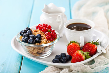 Breakfast - muesli, berries and coffee. Selective focus. Copy space