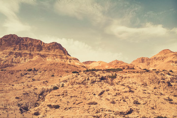 Scenic view of deserted area near a high rocky hill against the grey sky. Arid area at mountain...
