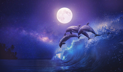 Night ocean with three playful dolphins leaping from sea on surfing wave and full moon shining on tropical background © willyam