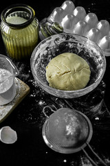 Ingredients for home baking: cookies, bread, cake. Flour, sugar, and eggs are on the black table. Baking dishes.