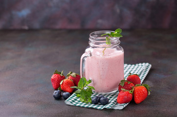 Smoothie in a jar and berries on a table. Selective focus. Copy space.