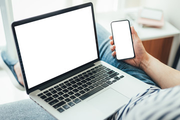 mockup image blank screen computer,cell phone with white background for advertising text,hand man using laptop texting mobile contact business search information on desk in cafe.marketing,design