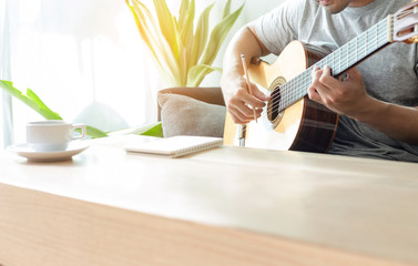 Fototapeta na wymiar artist songwriter thinking writing notes,lyrics in book at studio.man playing live acoustic guitar relax chill.concept for musician creative.composer work process.people relaxing time with instrument