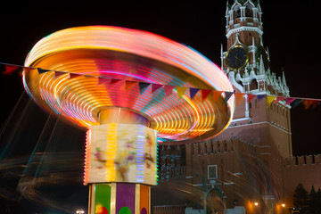 Merry-go-round near Spasskaya tower on the Red Square, Christmas market, Moscow, Russia.