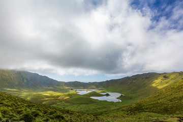 Beautiful parting clouds over the massive Corvo Caldera on the island of Corvo in the Azores, Portugal.