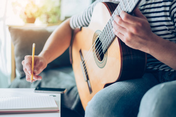 artist songwriter thinking writing notes,lyrics in book at studio.man playing live acoustic guitar relax chill.concept for musician creative.composer work process.people relaxing time with instrument