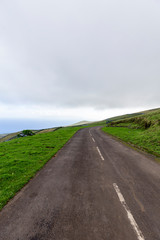 Fototapeta na wymiar Portrait view of the road leading to the Corvo Crater viewpoint on the island of Corvo in the Azores, Portugal.
